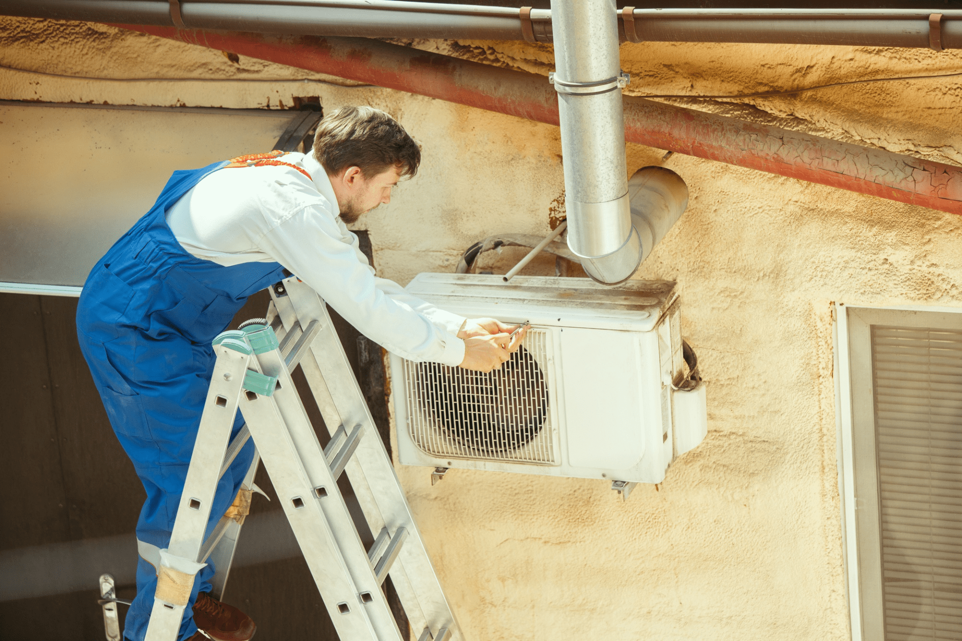 hvac technician working on a capacitor part for condensing unit. male worker or repairman in uniform repairing